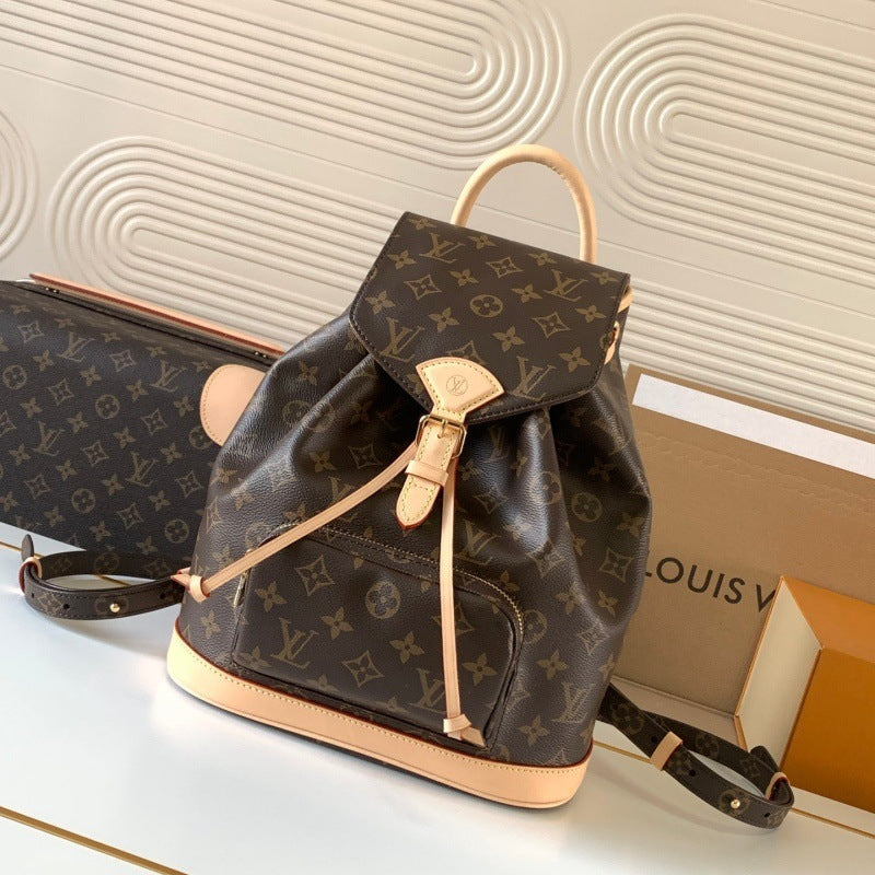 Louis Vuitton monogram canvas backpack in dark brown with light tan leather trim, shown with a matching zip case and Louis Vuitton box on a light surface against a patterned beige wall.
