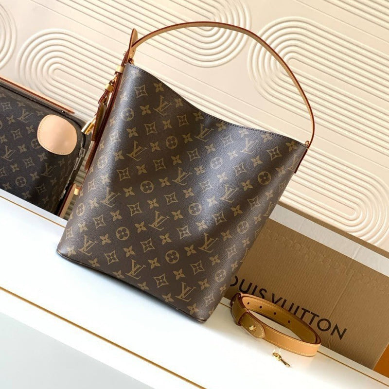 A Louis Vuitton monogram canvas shoulder bag in brown and tan, displayed on a white surface with a Louis Vuitton box and another matching bag in the background.