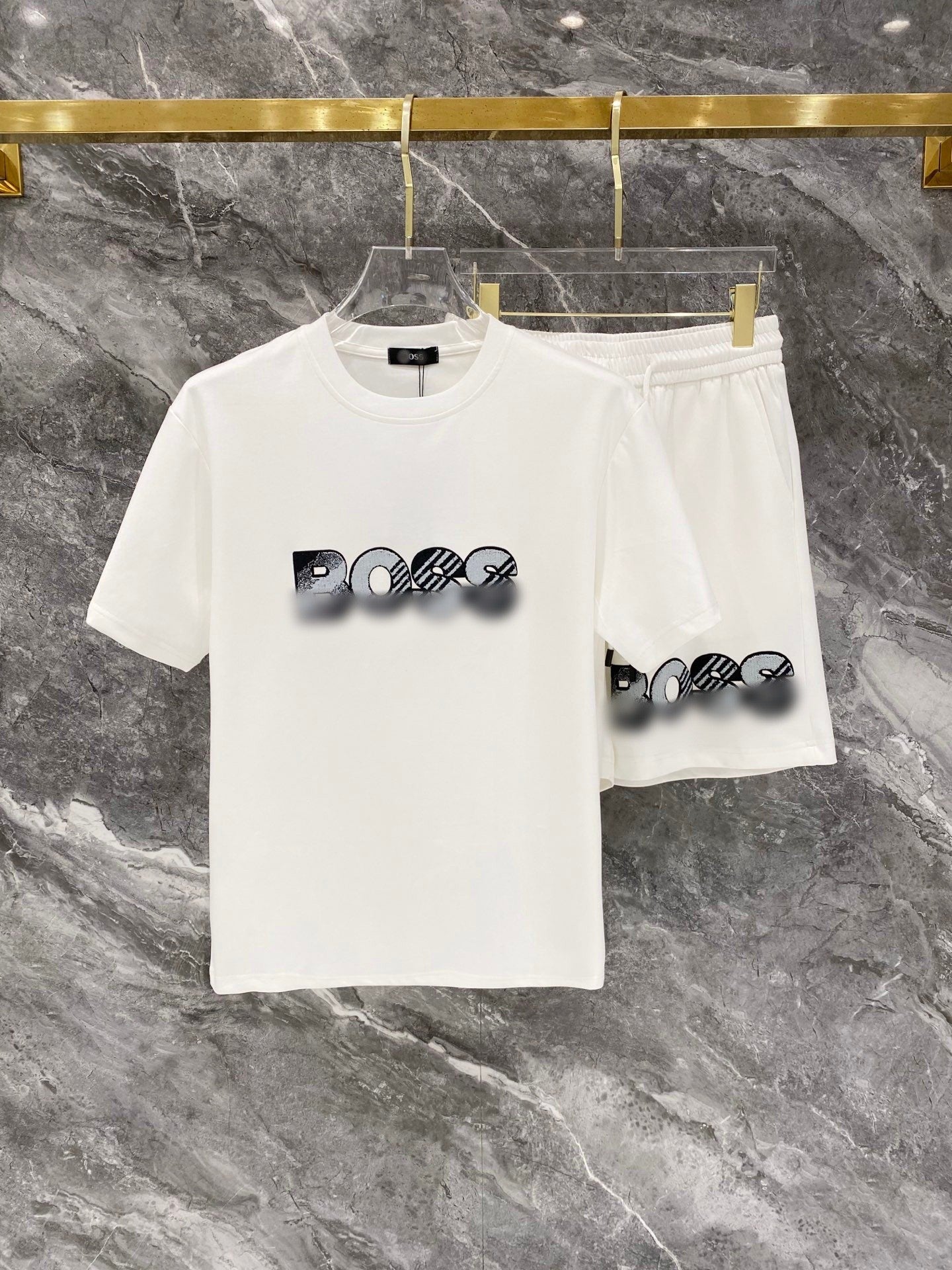 White t-shirt and shorts set with graphic design on a marble surface