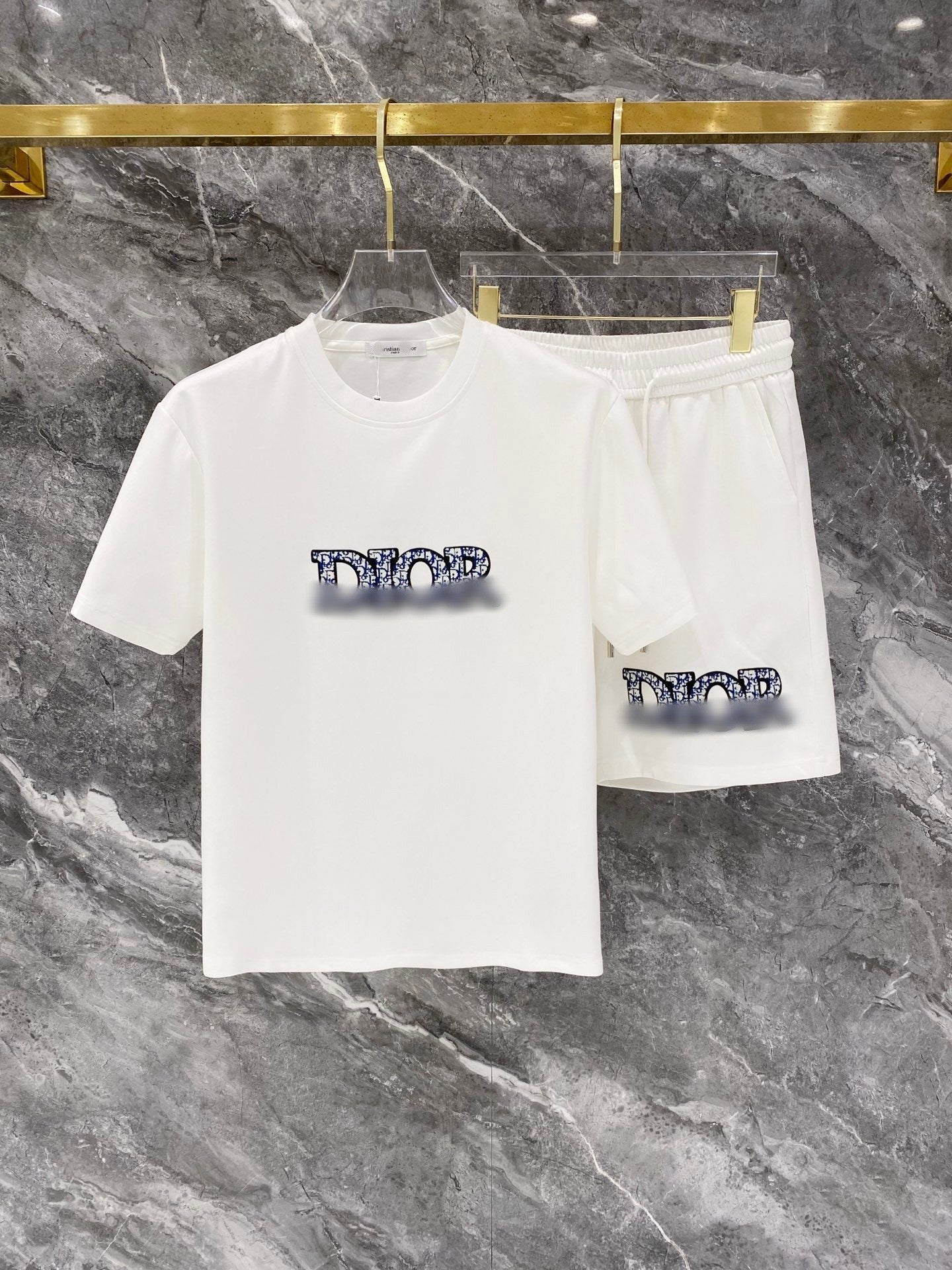 White t-shirt and shorts set with graphic design on a marble surface