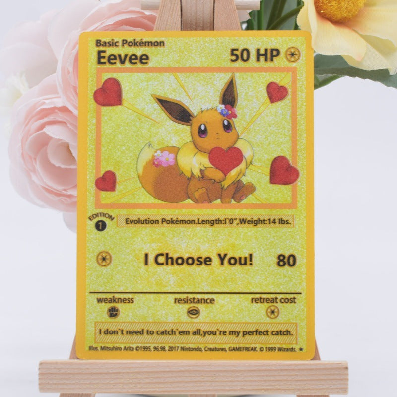 A holographic Pokémon Eevee trading card displayed on a small wooden stand, with pink and yellow flowers blurred in the background.