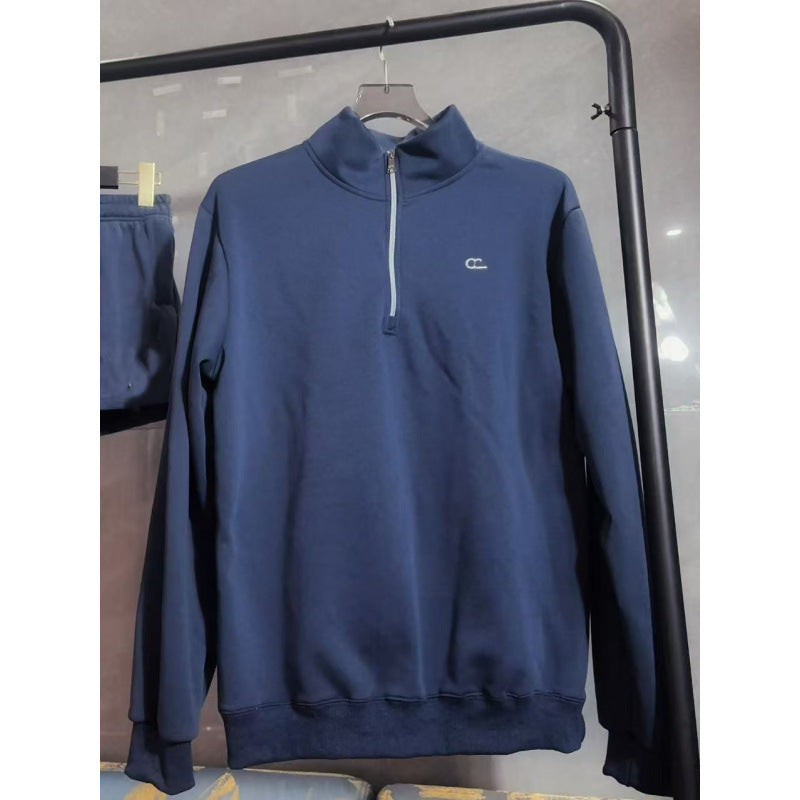 Blue sweatshirt with a small logo on a hanger against a neutral background