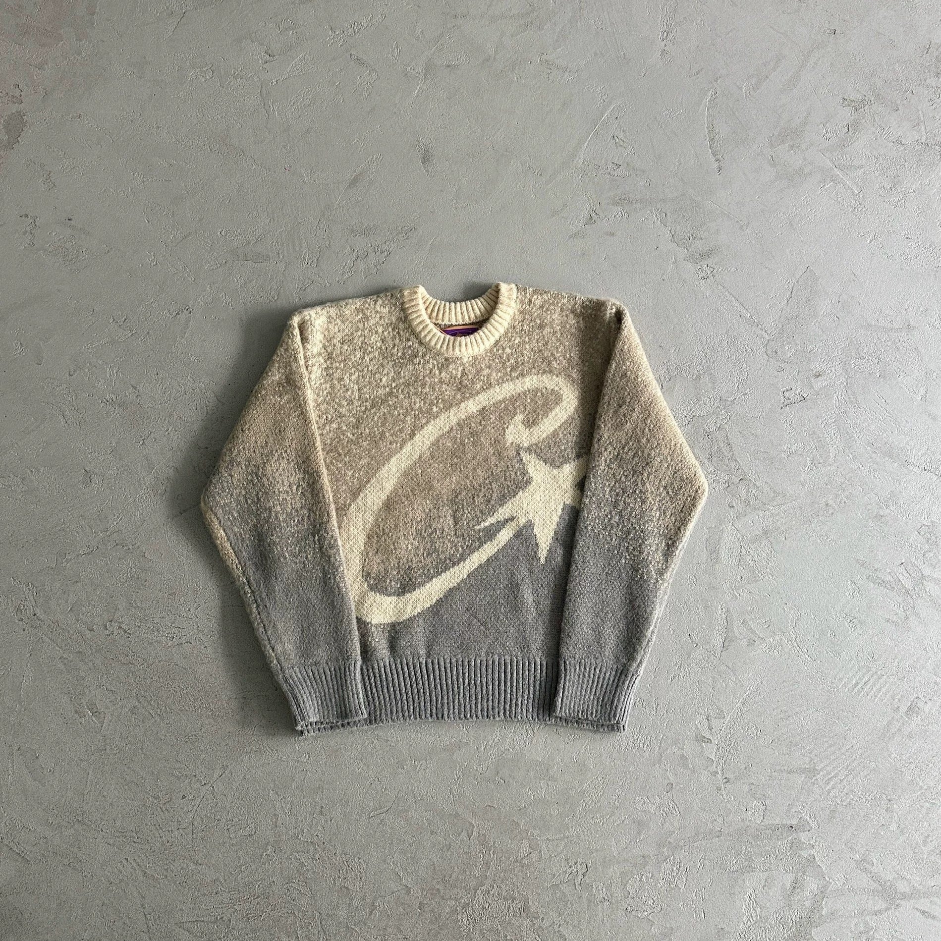 Gray sweater with a large white logo on a gray background