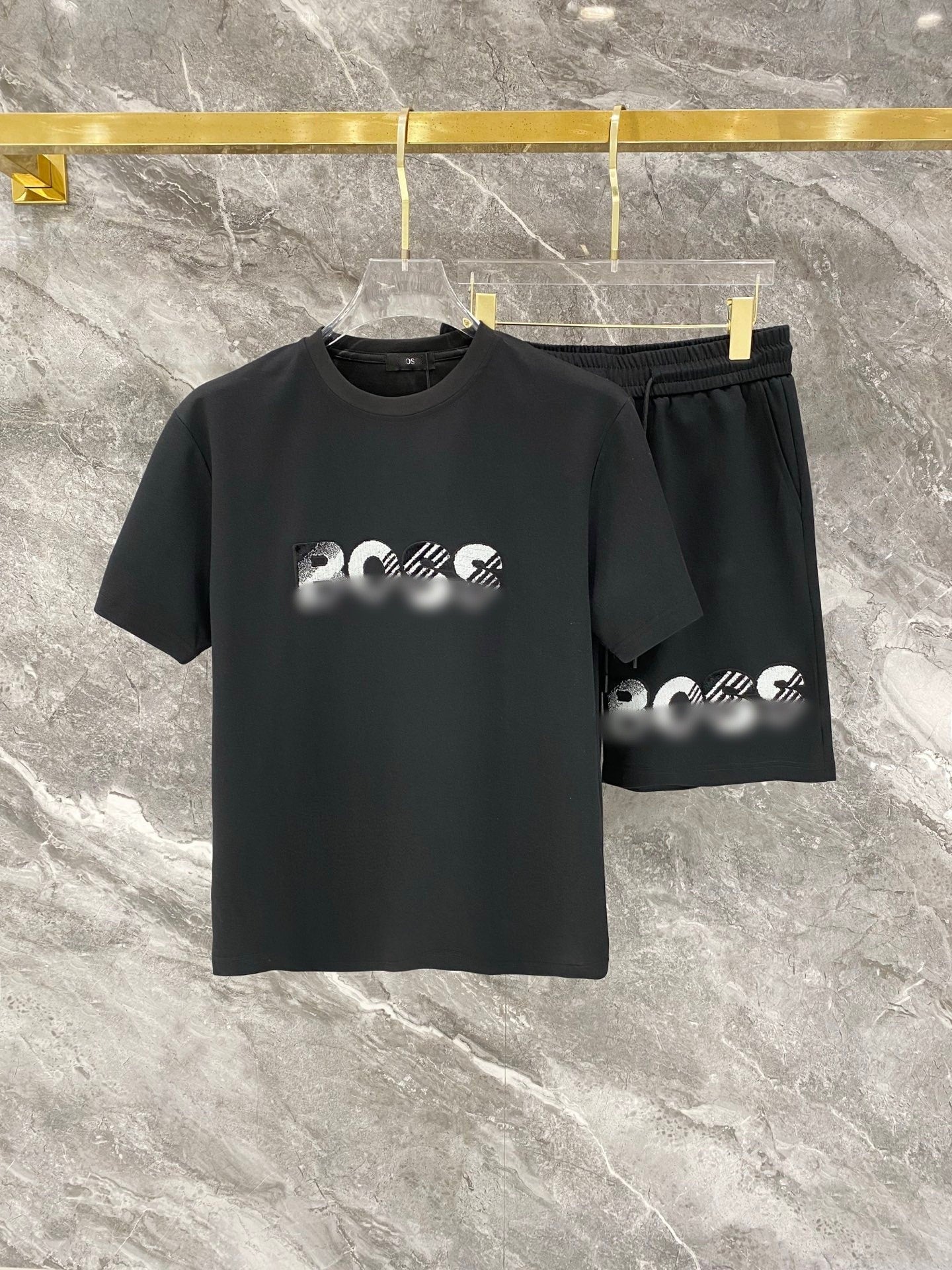 Black t-shirt and shorts set with logo on a marble surface