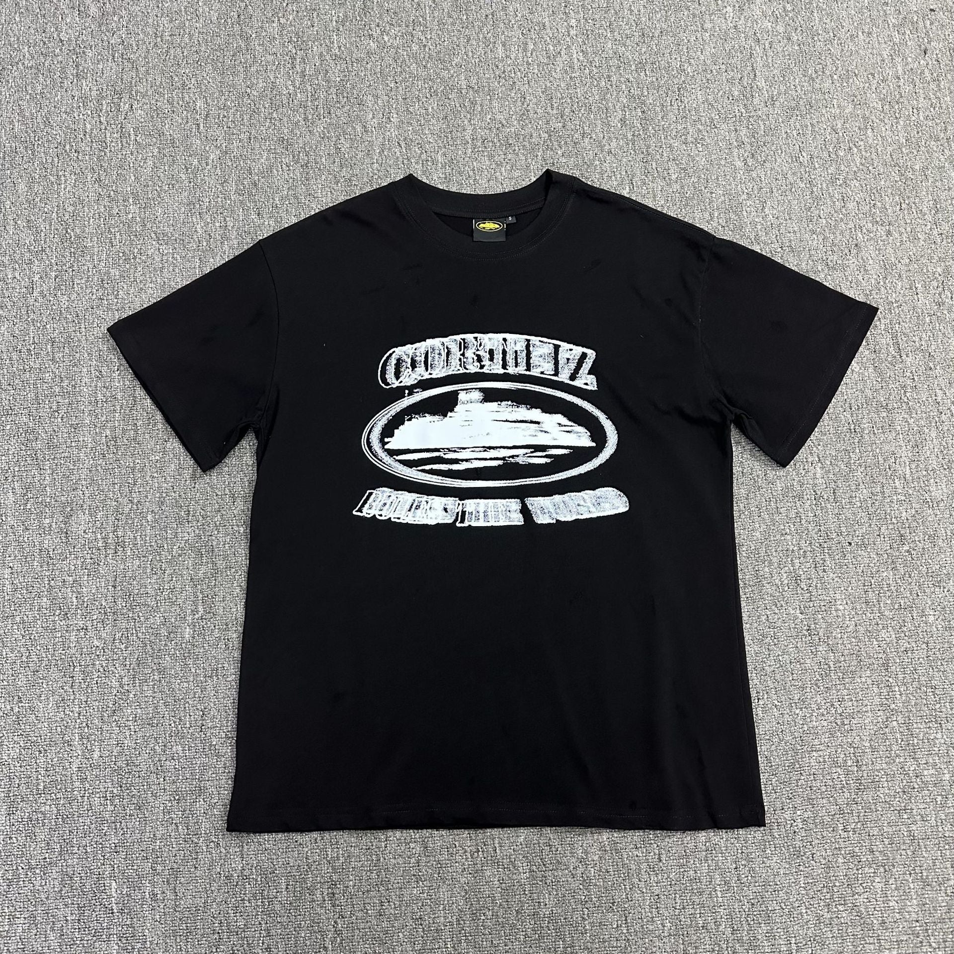 Black t-shirt with white graphic design on a gray background