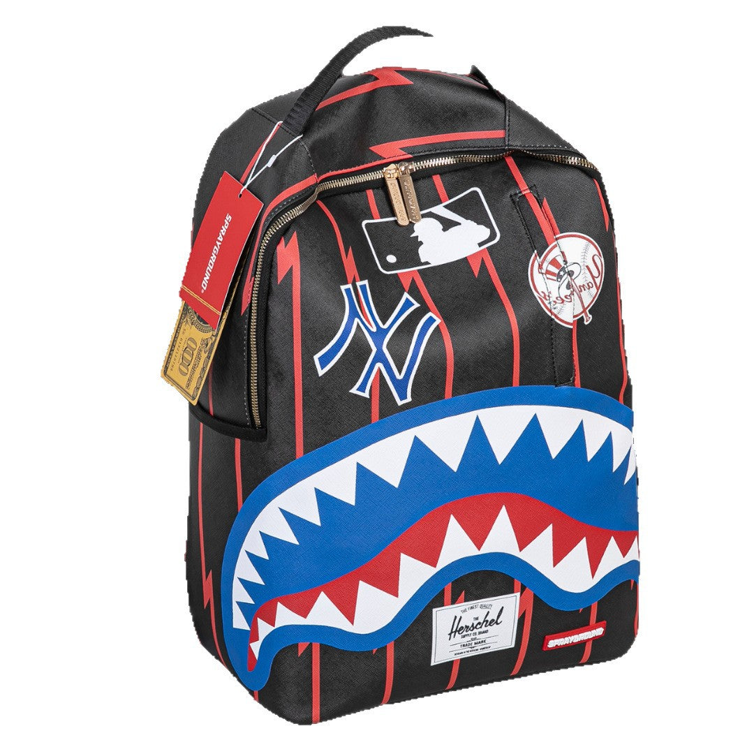 A black backpack featuring red pinstripes, a large blue and red shark mouth graphic on the front, a New York Yankees logo, and a Herschel brand patch near the bottom.