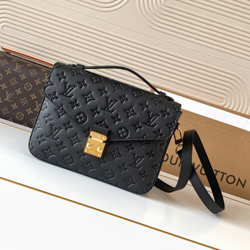 A black Louis Vuitton monogram embossed leather shoulder bag with a gold-tone padlock clasp, displayed on a white surface with a Louis Vuitton box in the background.
