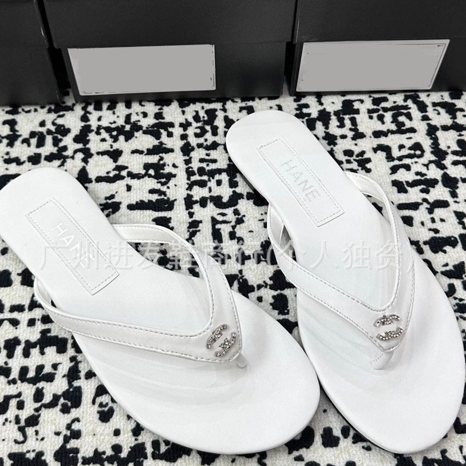 White sandals with a brand logo on a patterned surface