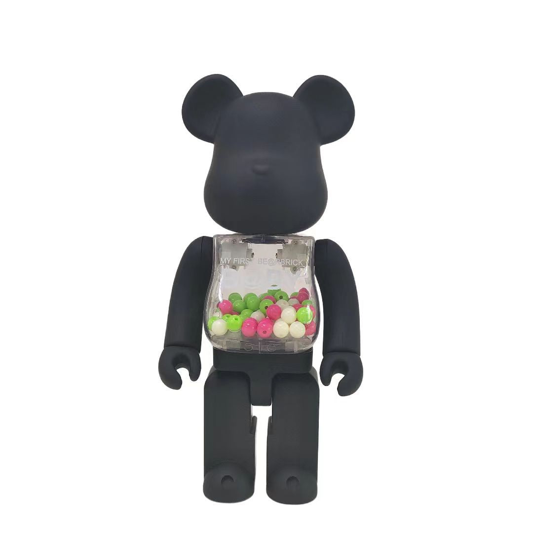 A matte black bear-shaped collectible figure with a transparent chest compartment filled with small colorful candies, shown against a plain white background.