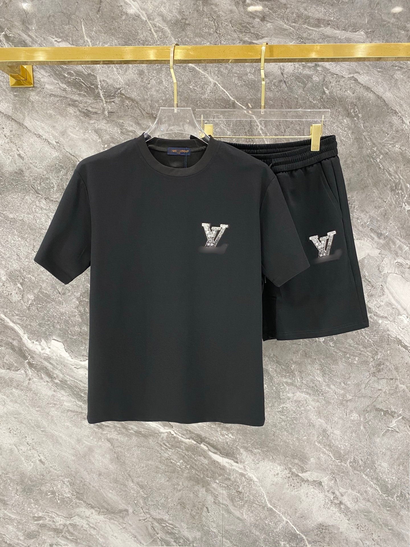 Black t-shirt and shorts set with logo on a marble surface