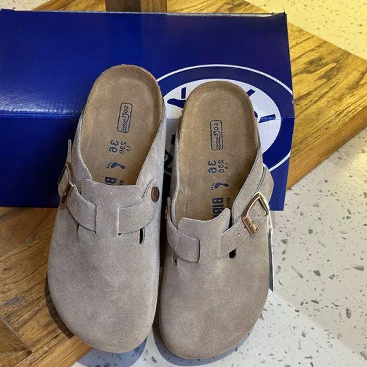 Pair of beige clogs with a blue box in the background