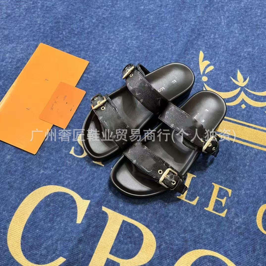 Black sandals with gold buckles on a blue surface with yellow text