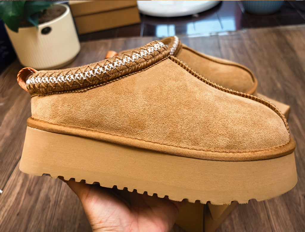 Tan winter boots with fur-lined interior on a wooden surface