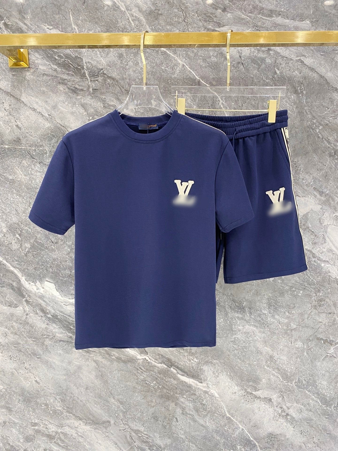 Navy blue t-shirt and shorts set with brand logo on a marble surface