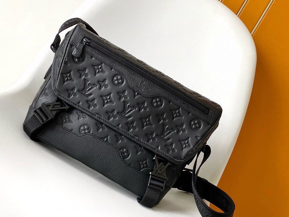Black embossed handbag on a white surface with an orange background