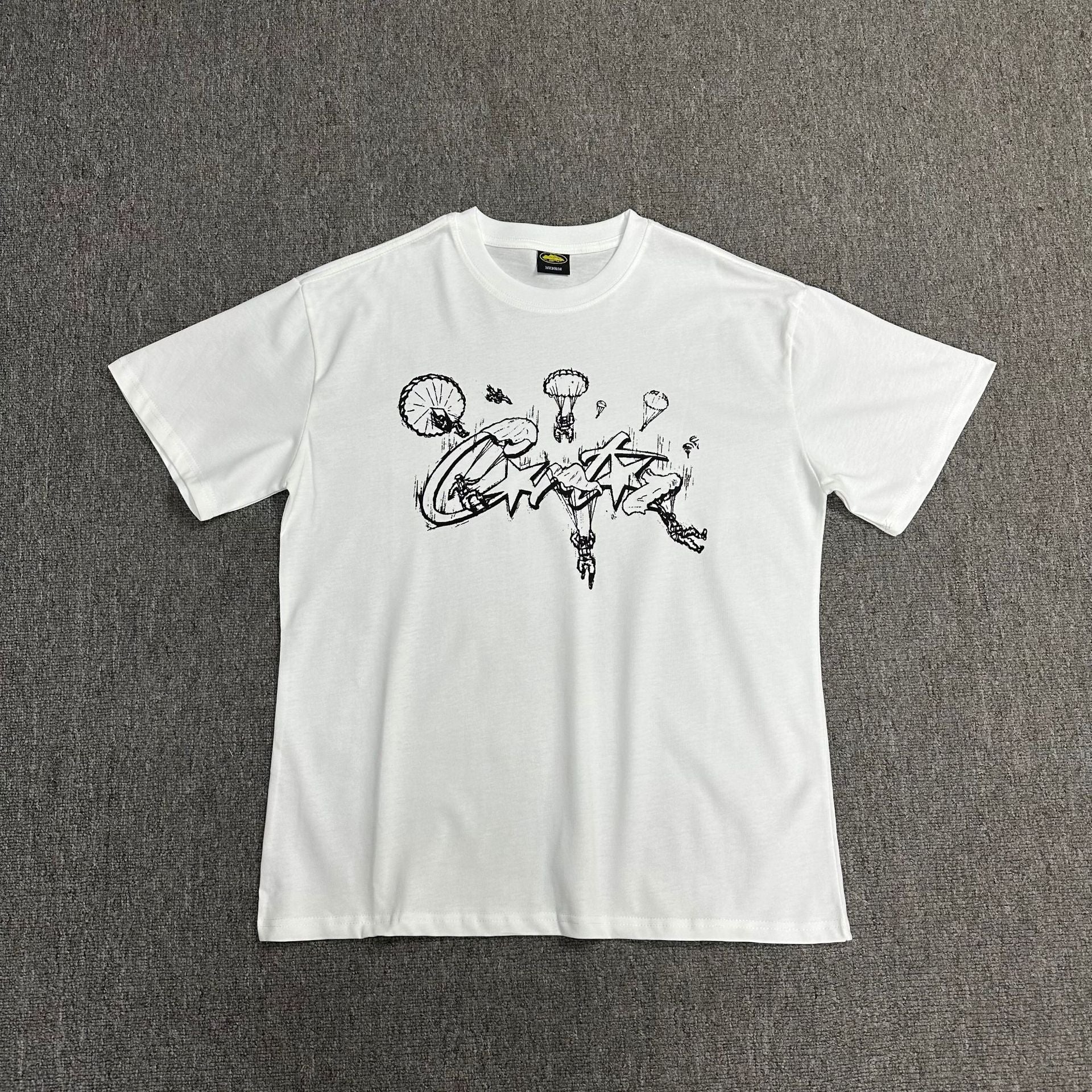 White t-shirt with black graphic design on a gray background
