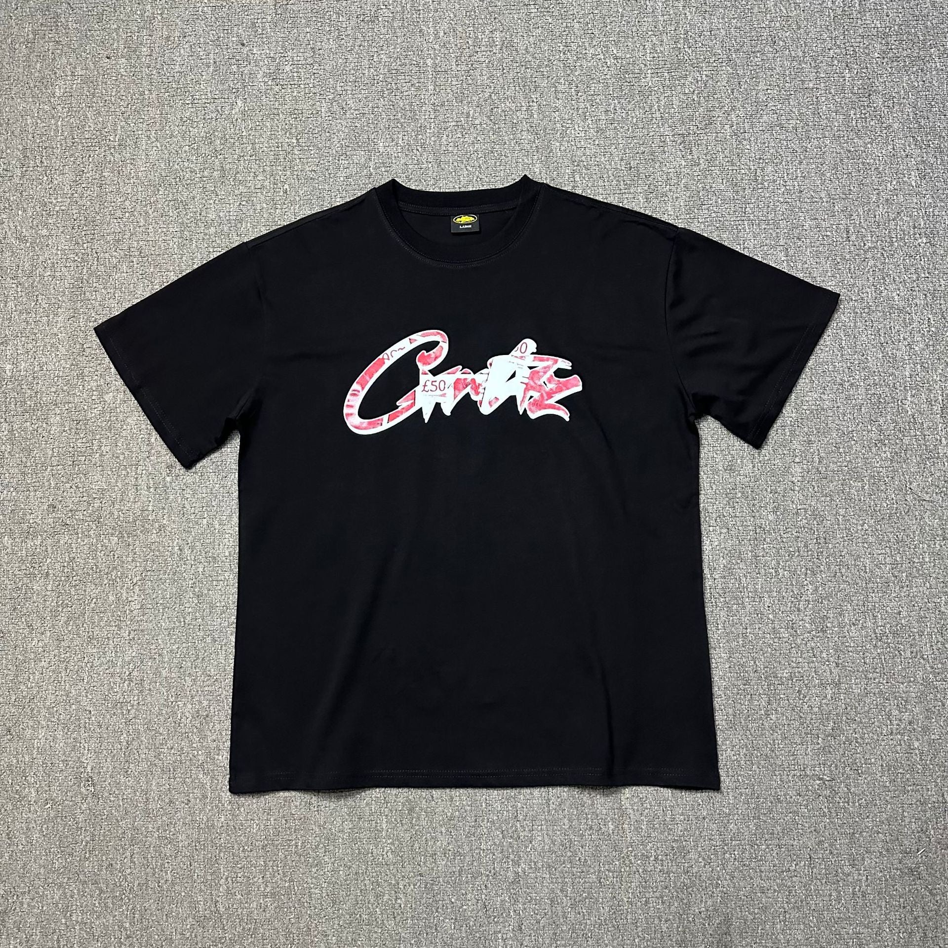 Black t-shirt with colorful logo on a gray textured background