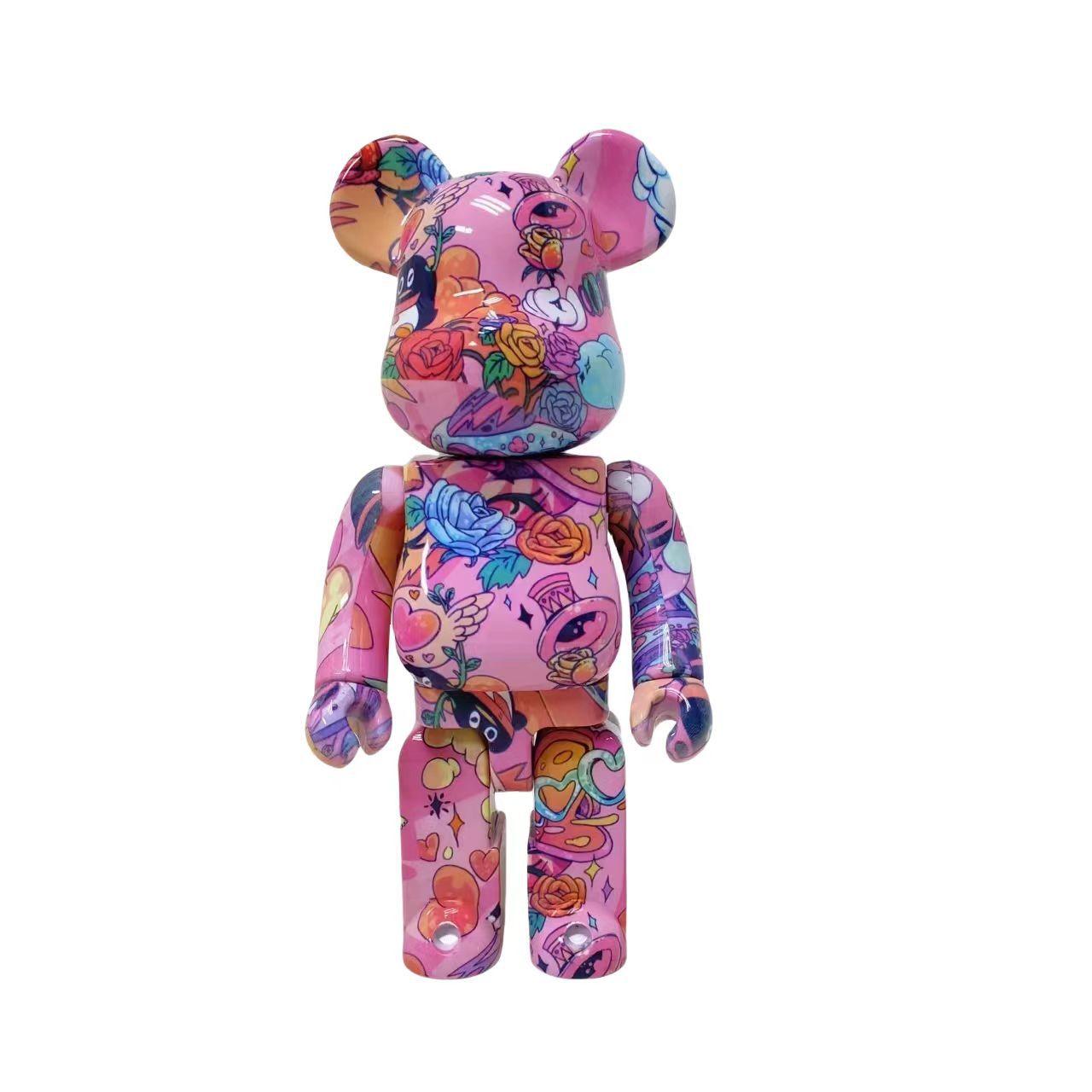 A pink bear-shaped collectible figure covered in a colorful graffiti-style floral and cartoon pattern, shown against a plain white background.