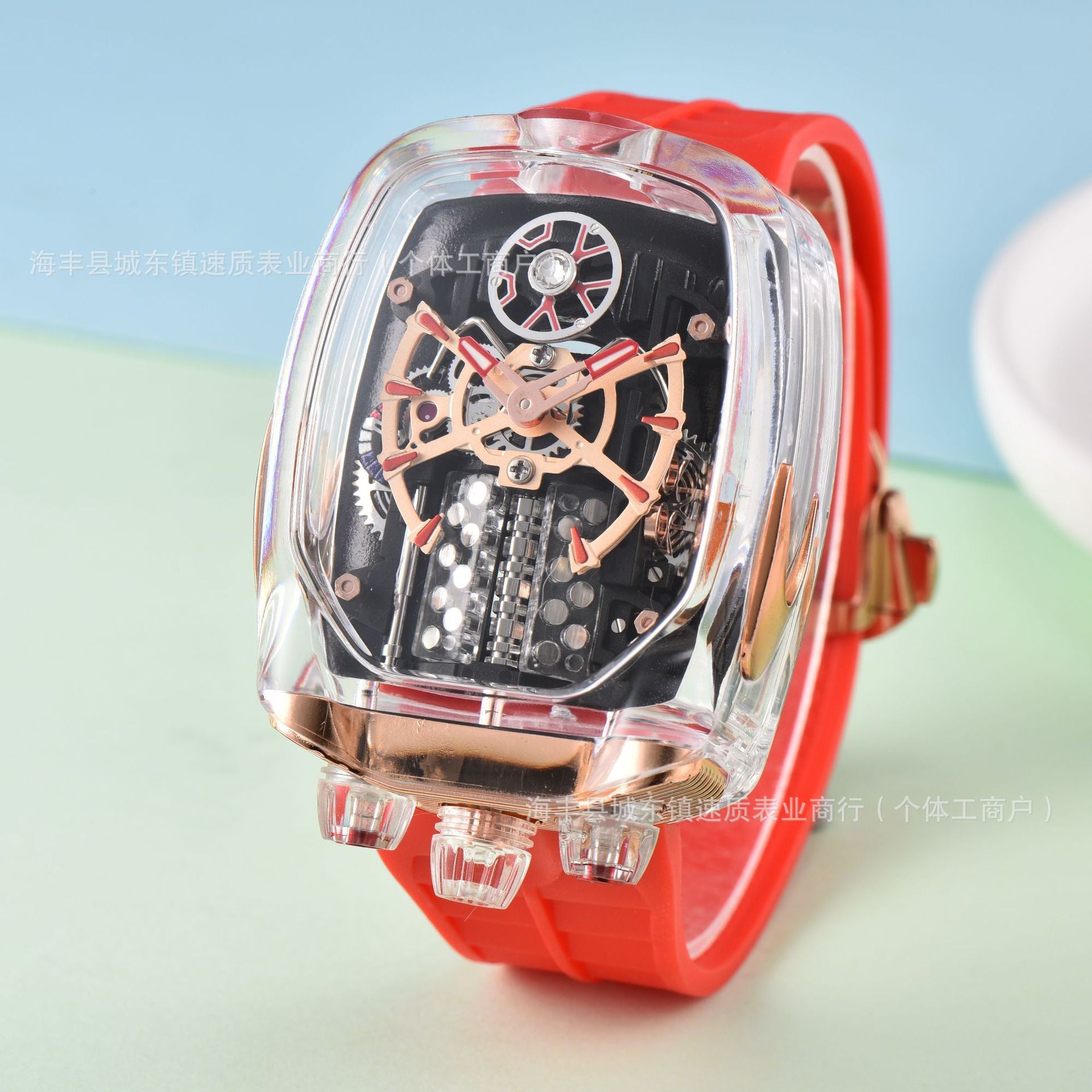 Watch with transparent case and red strap on a light blue and green gradient background