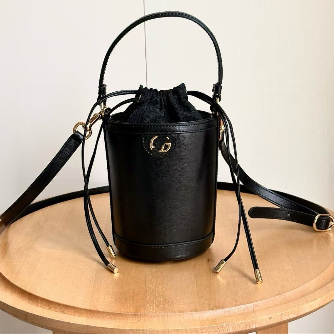 Black handbag with a brand logo on a wooden surface
