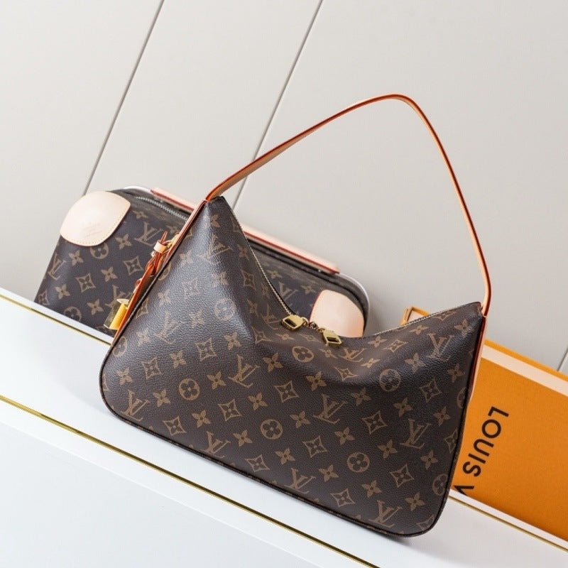 Louis Vuitton monogram canvas shoulder bag with a brown leather handle, displayed on a white surface next to its orange Louis Vuitton box.