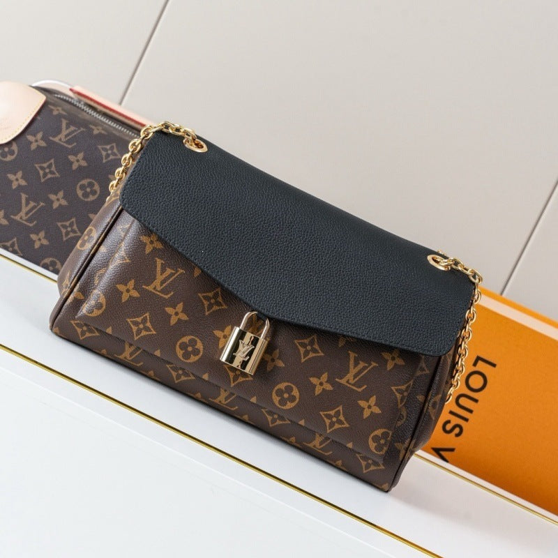 Louis Vuitton monogram canvas shoulder bag with a black leather flap and gold-tone chain strap, displayed on a white surface with an orange Louis Vuitton box in the background.