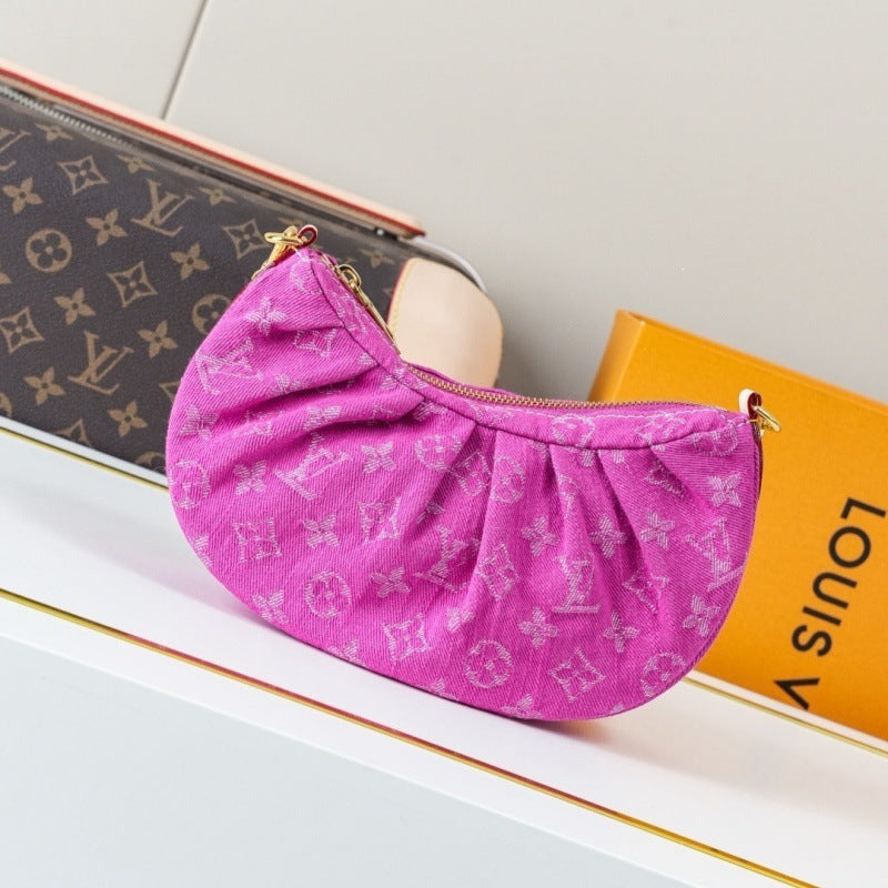 A pink Louis Vuitton monogram pouch bag with gold-tone hardware, styled on a white surface next to a Louis Vuitton monogram case and an orange Louis Vuitton box.