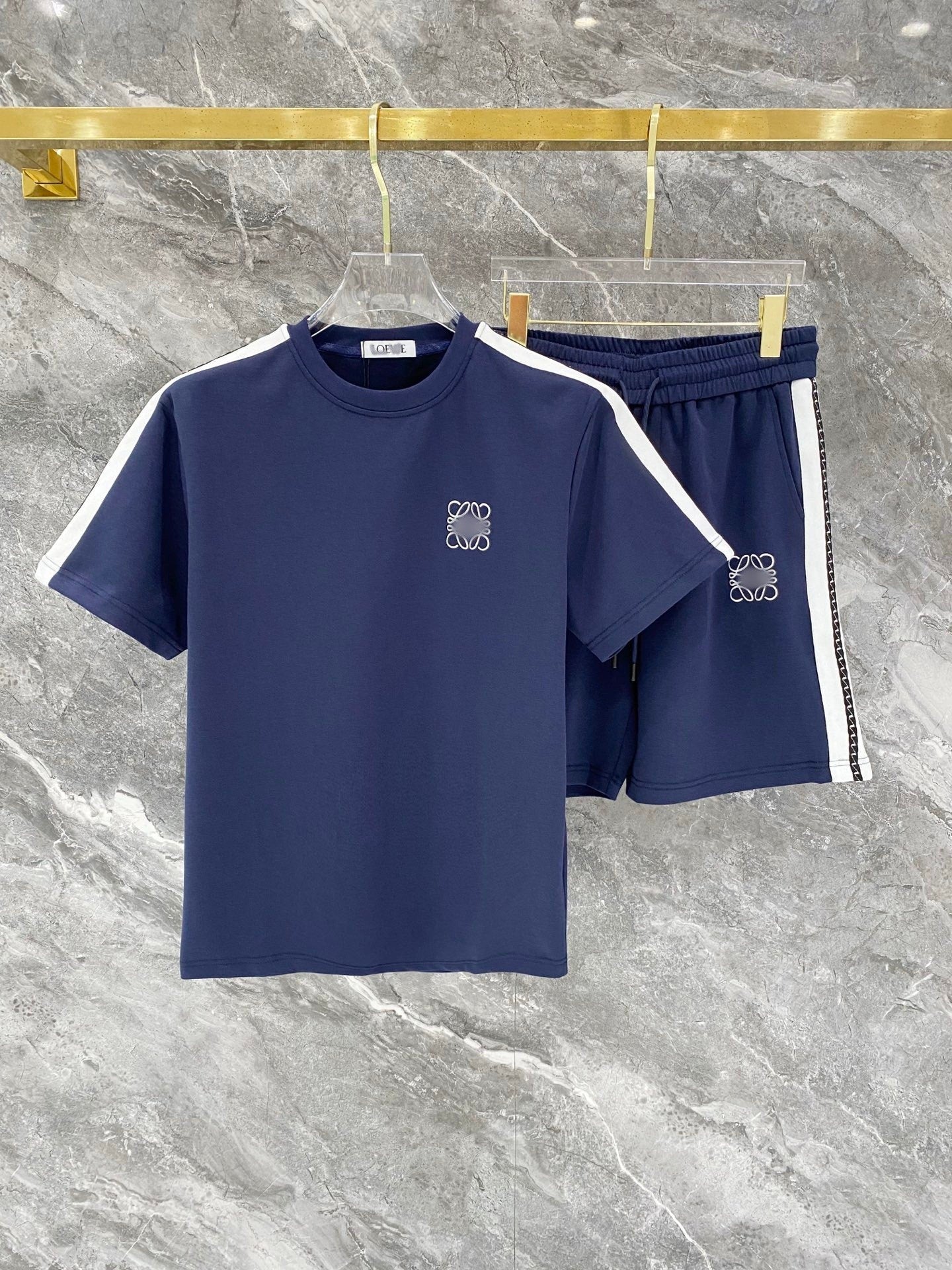 Navy blue t-shirt and shorts set with white accents on a marble surface
