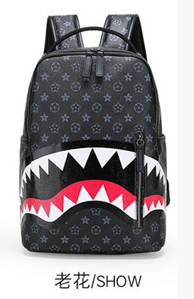 A black backpack featuring a repeating monogram pattern and a shark-mouth graphic in white, black, and red across the lower front, shown on a plain white background with Chinese text below.