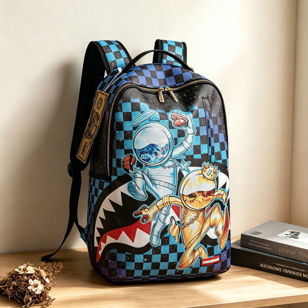 A backpack with a blue and black checkered pattern and a cartoon astronaut and cat graphic, displayed on a wooden shelf next to books.