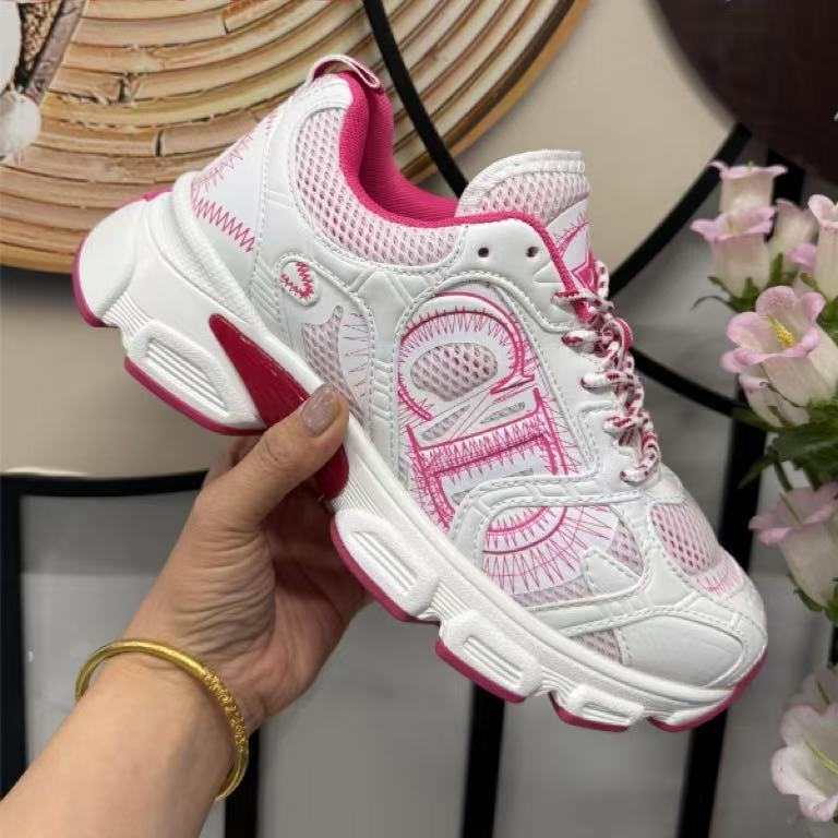 White and pink sneaker held by a hand with a blurred background