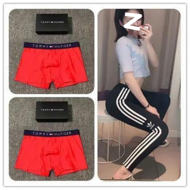 Red Tommy Hilfiger boxer briefs with packaging and a person wearing black Adidas pants.