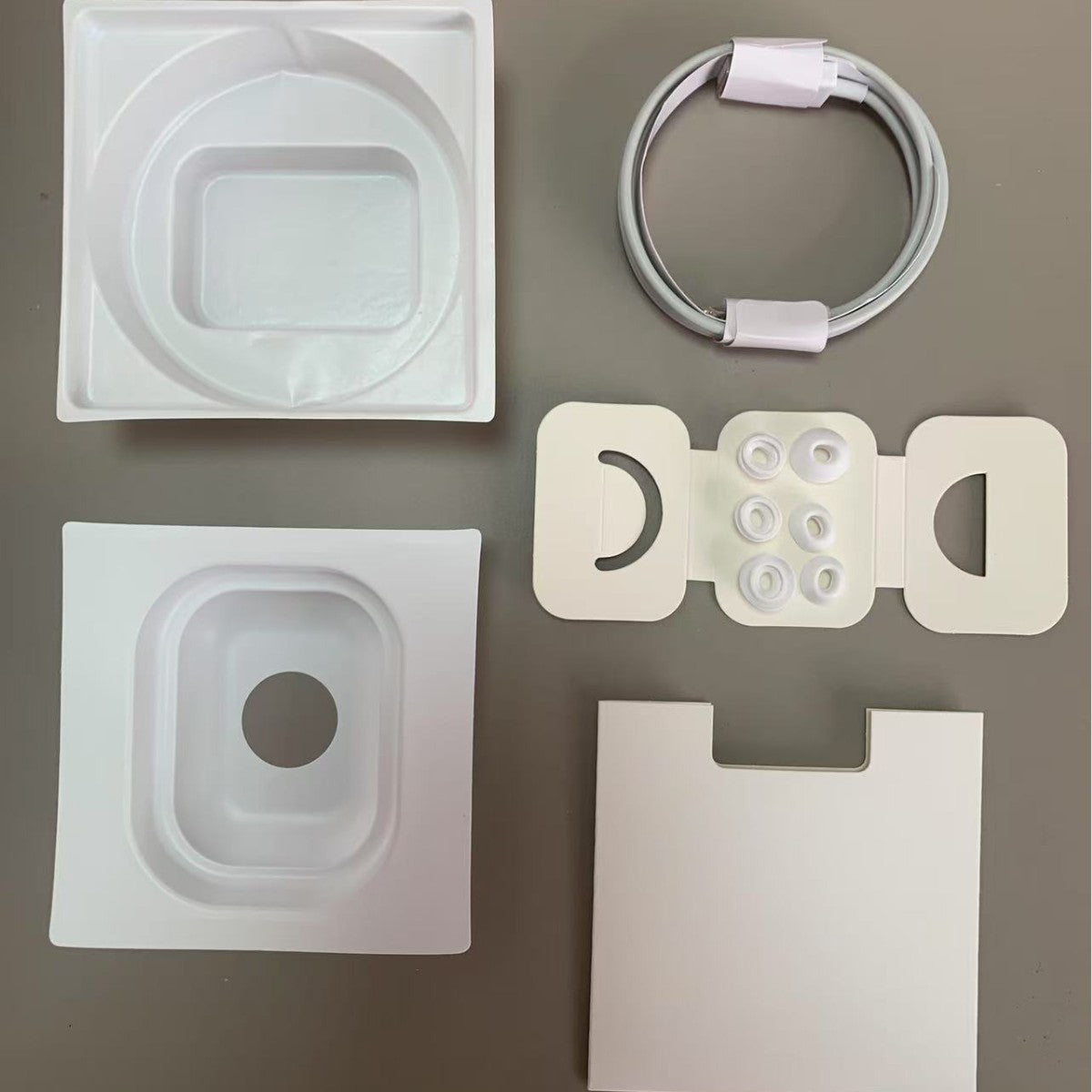 Set of electronic components including a cable, connectors, and a white box on a gray background
