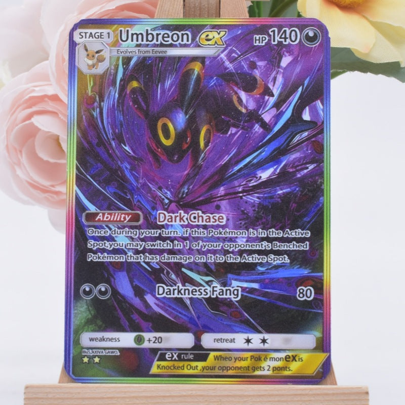A holographic Pokémon trading card featuring the Umbreon EX character, displayed on a small wooden stand with soft pink and yellow flowers in the background.