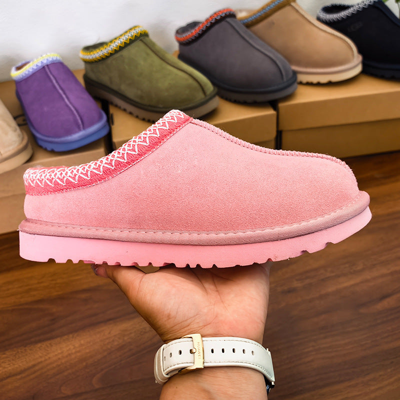 Pink slippers on a wooden floor with shoes in the background