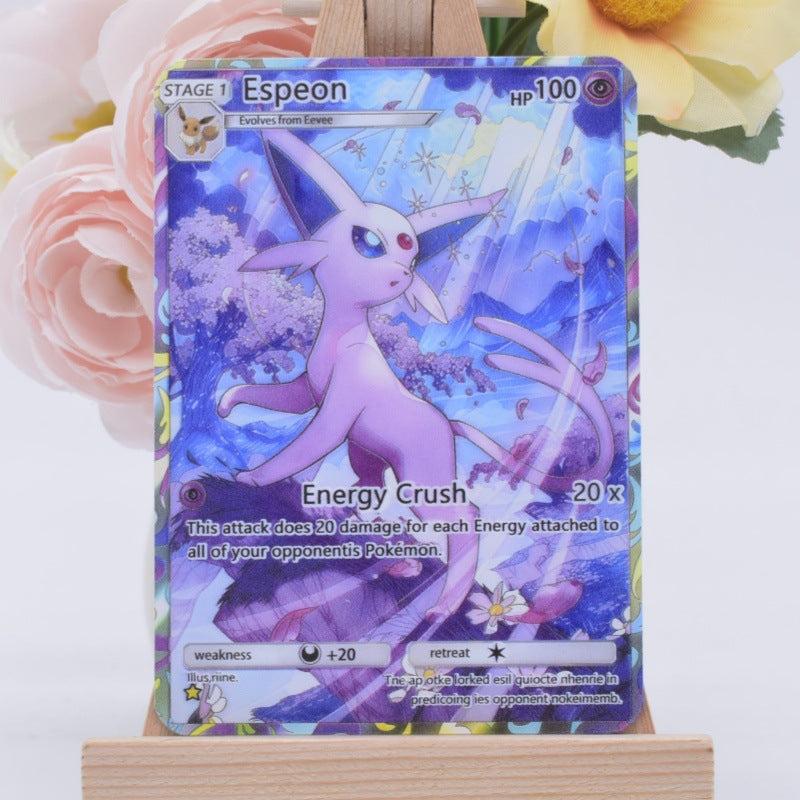 A holographic Espeon Pokémon trading card displayed on a small wooden stand, with soft pink and yellow flowers blurred in the background.