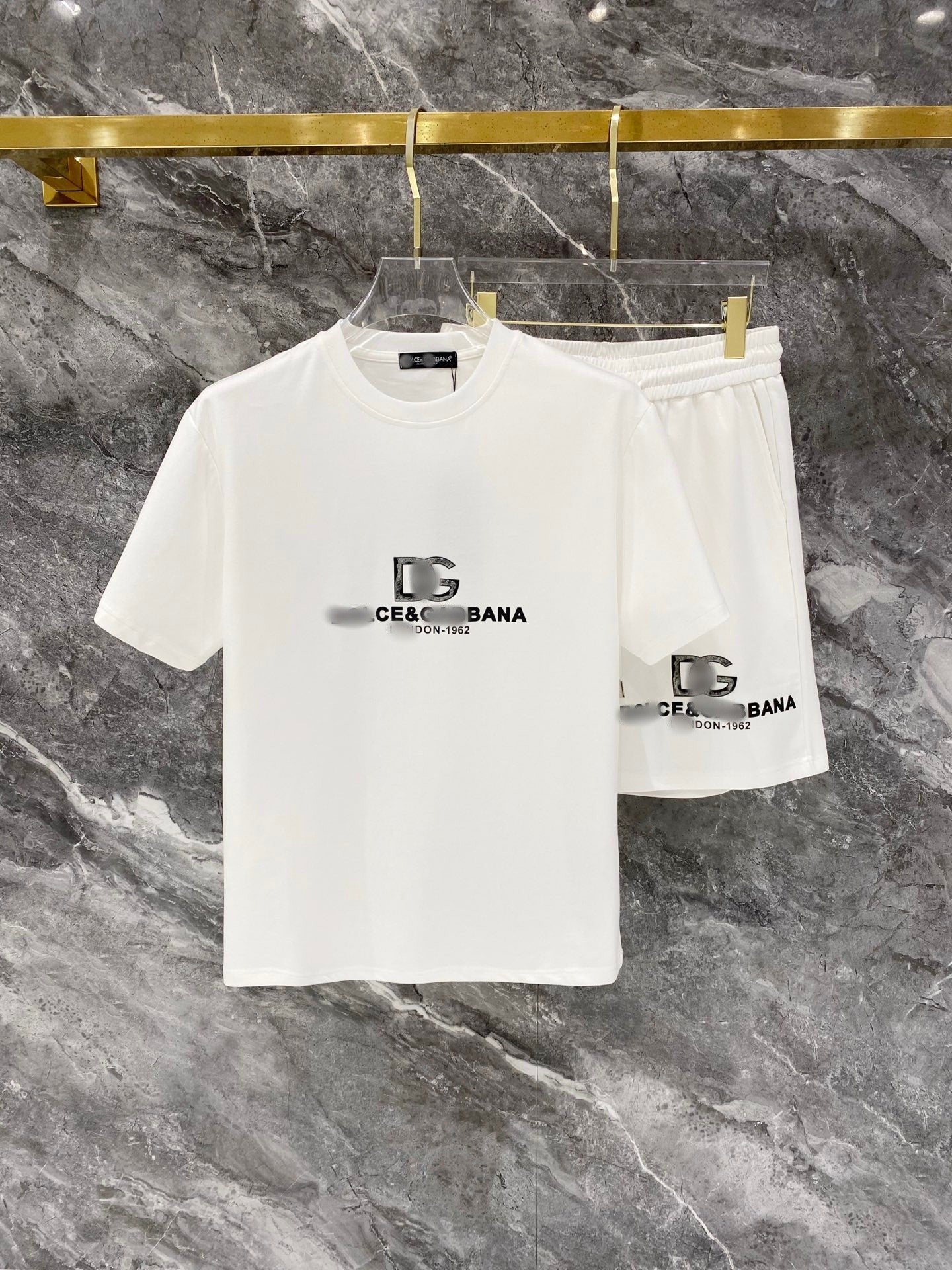 White t-shirt and shorts set with brand logo on a marble surface