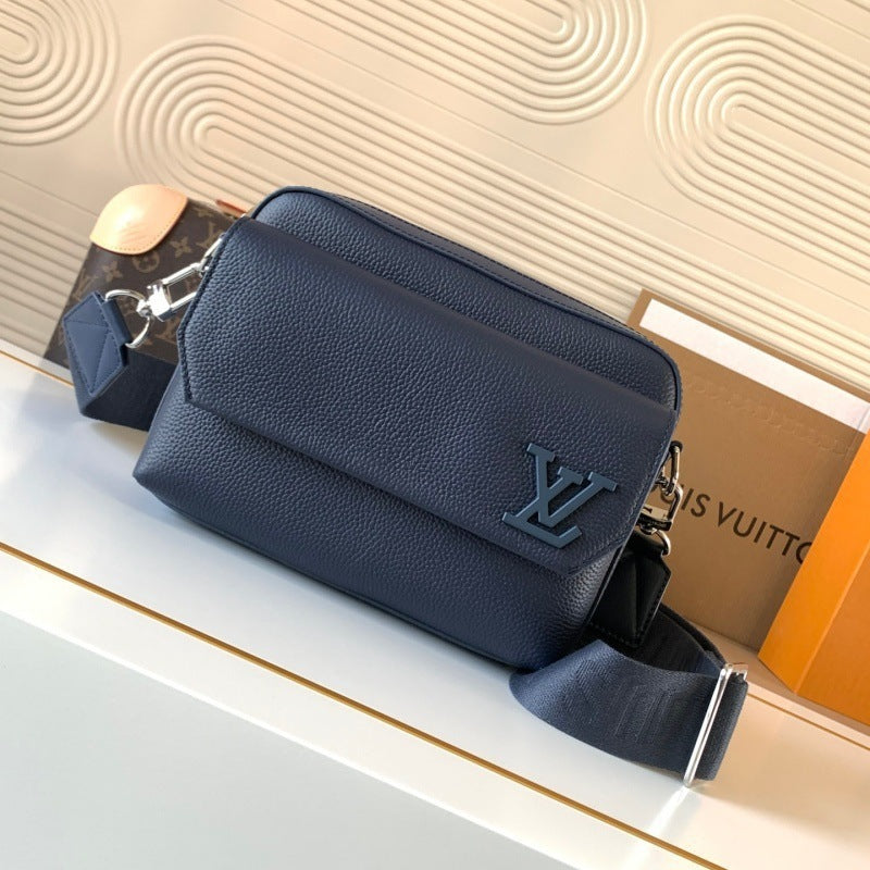 A Louis Vuitton navy blue pebbled leather crossbody bag with a matching monogram pouch and strap, displayed on a white surface with a branded box in the background.
