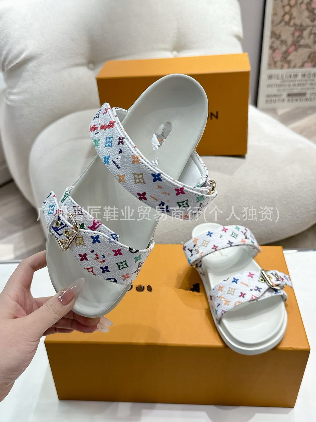 White sandals with colorful pattern on a Louis Vuitton box