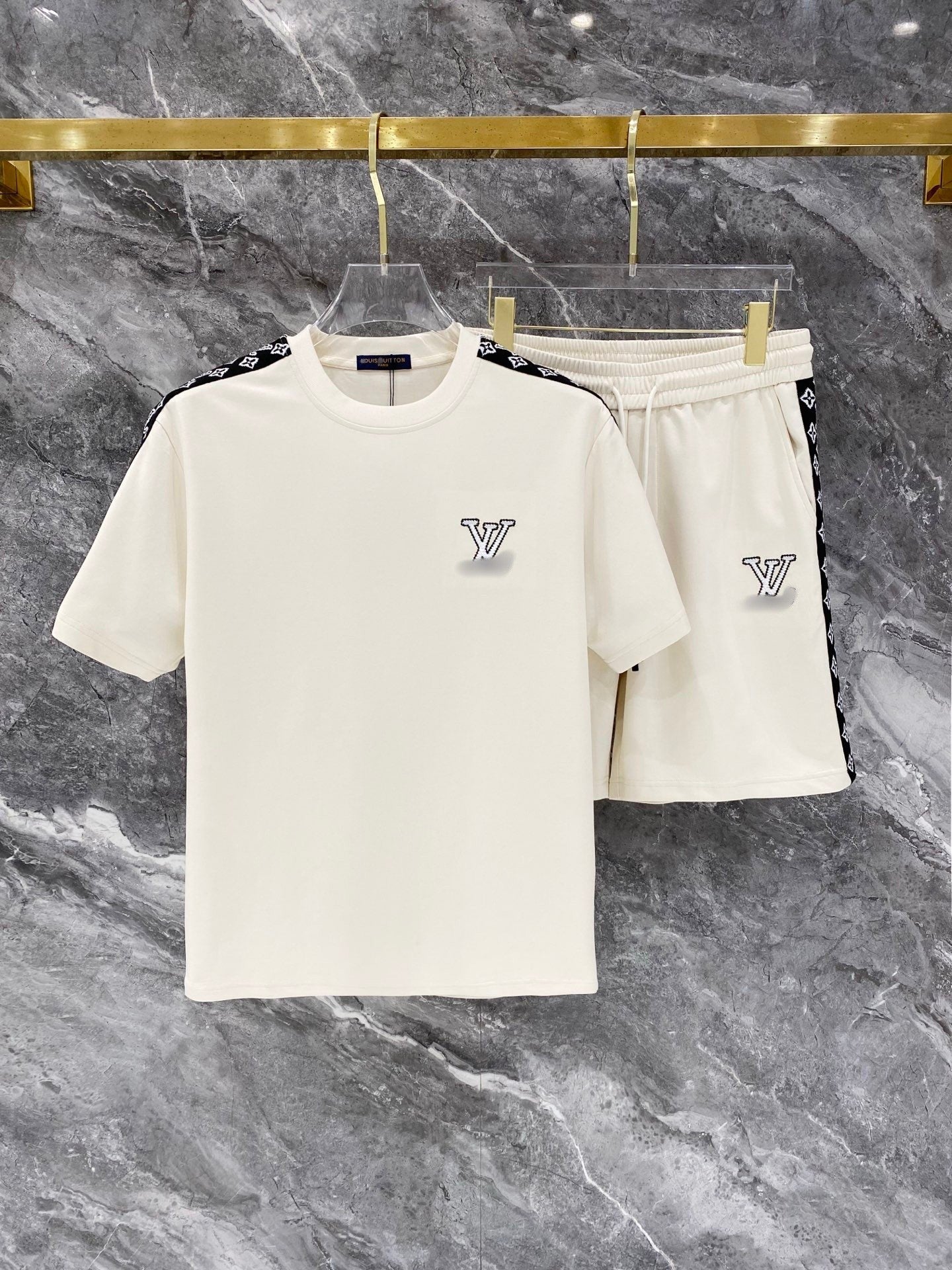 White t-shirt and shorts set with brand logo on a marble surface
