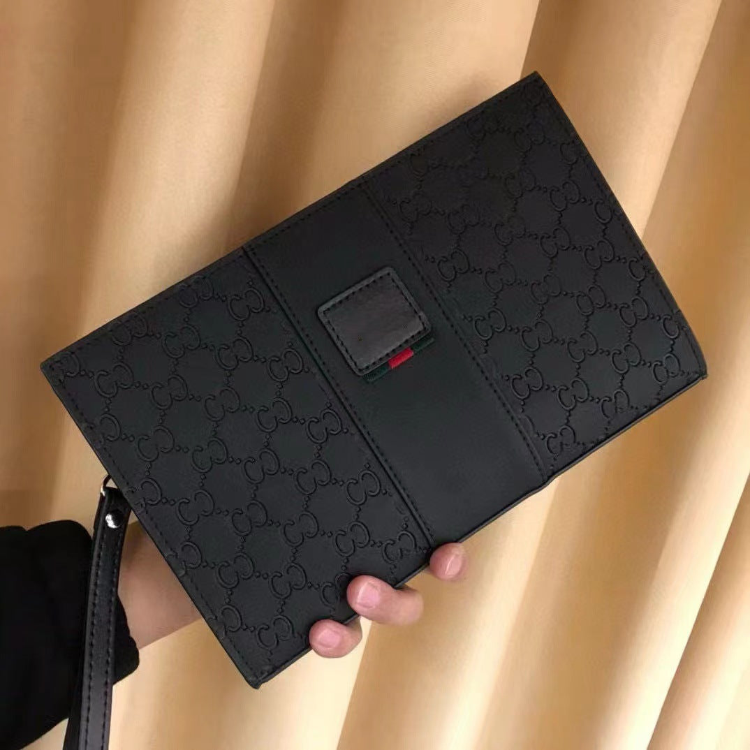 A black Gucci clutch bag with the brand's iconic GG monogram pattern, held by a hand against a backdrop of beige draped curtains.