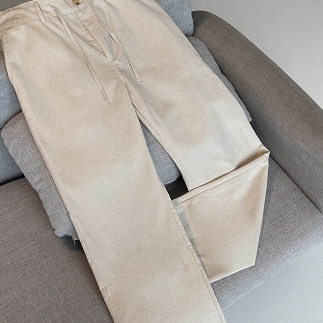 Beige drawstring trousers laid flat on a gray sofa, with a YOULIN brand logo in the top left corner and Chinese promotional text banners at the bottom.