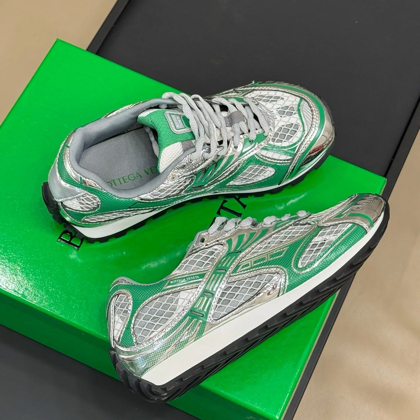 Green and white sneakers on a green box with a black background