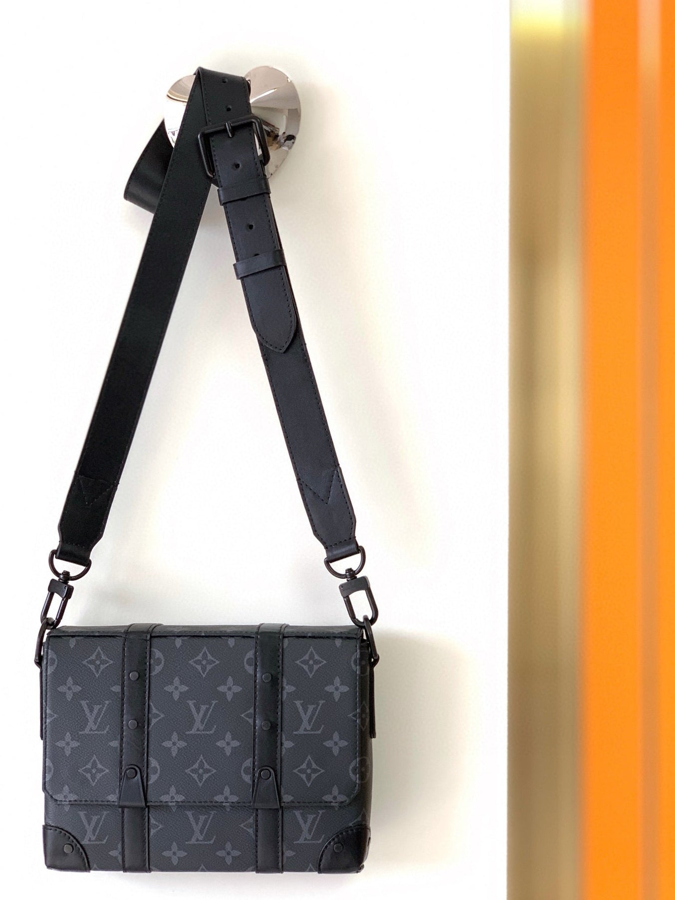 Black patterned bag with a strap on a white background