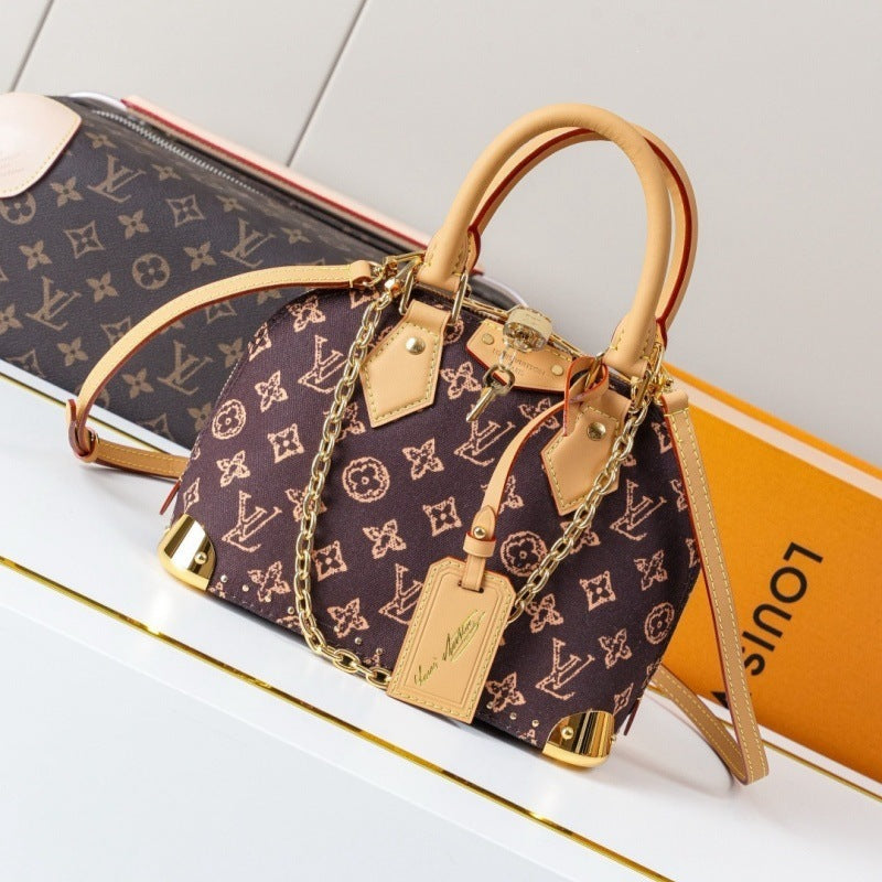 Louis Vuitton monogram canvas handbag with tan leather trim, gold-tone chain strap, and hardware, displayed on a white surface with a Louis Vuitton box in the background.