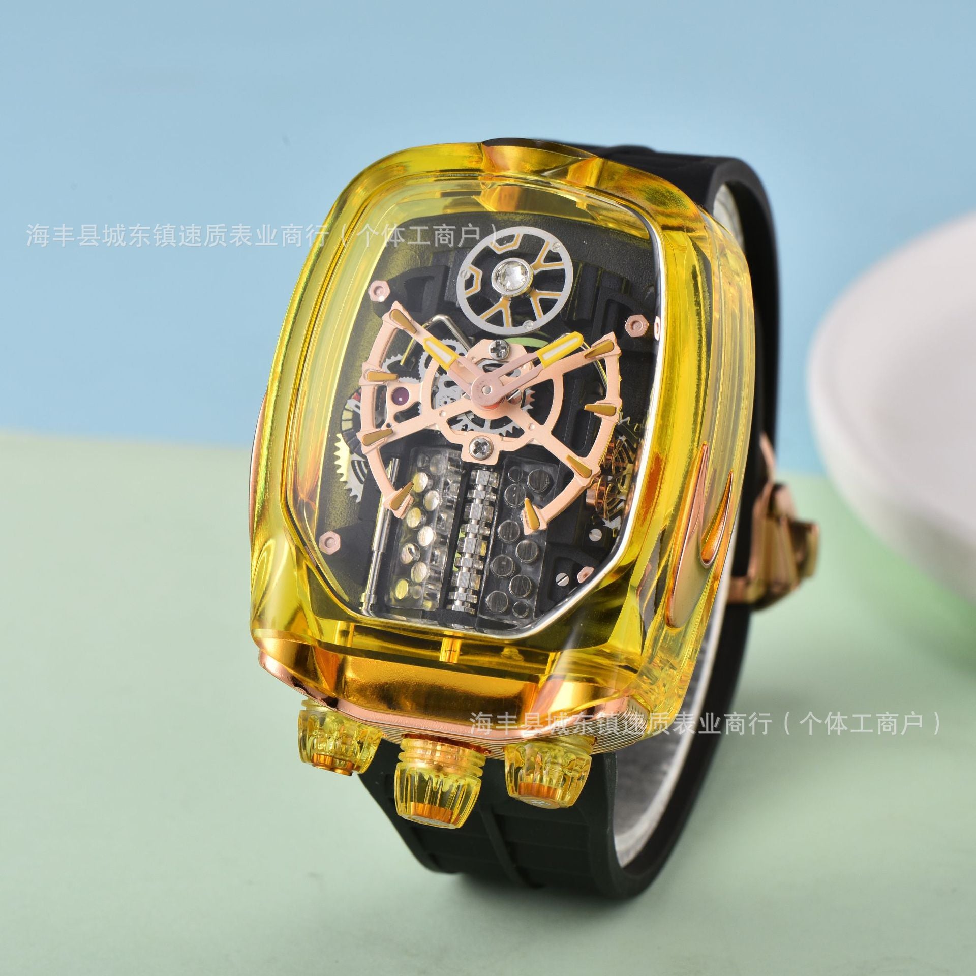 Wristwatch with transparent yellow case and black strap on a light blue and green gradient background