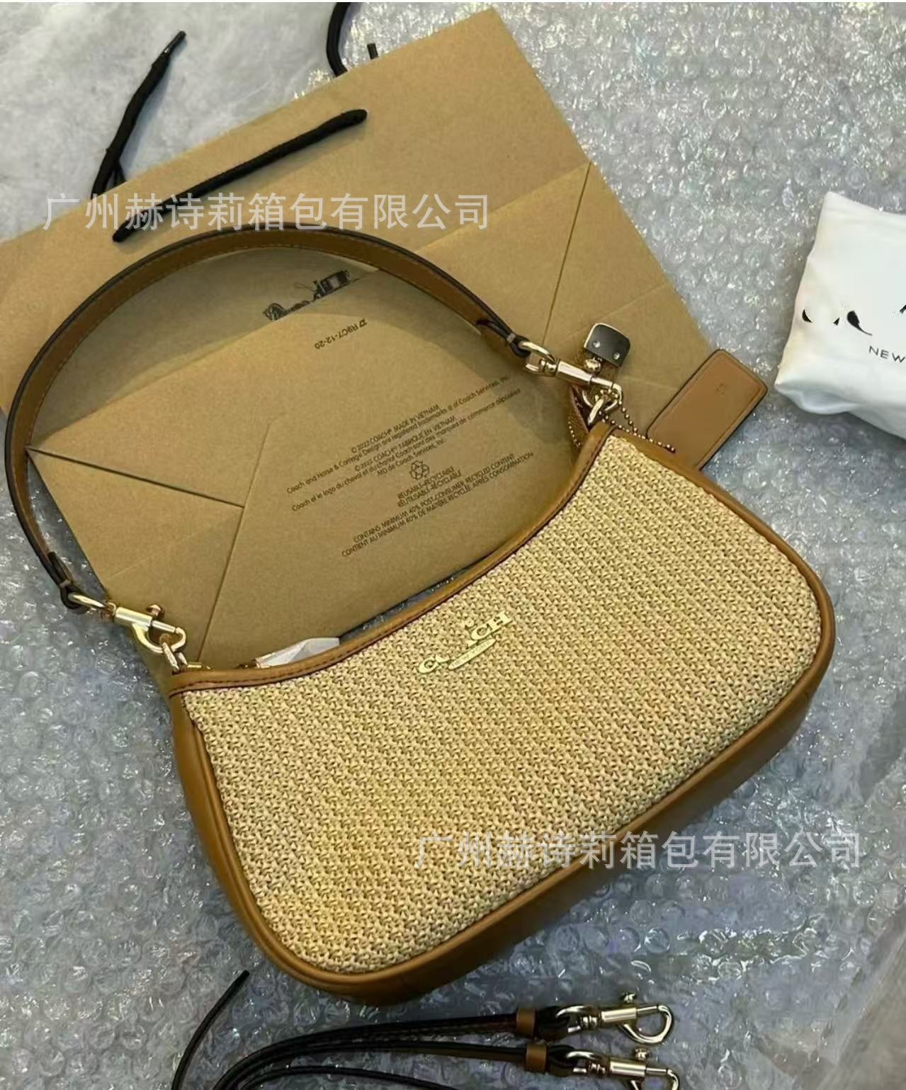 Brown handbag with textured surface and visible brand name on a gray background