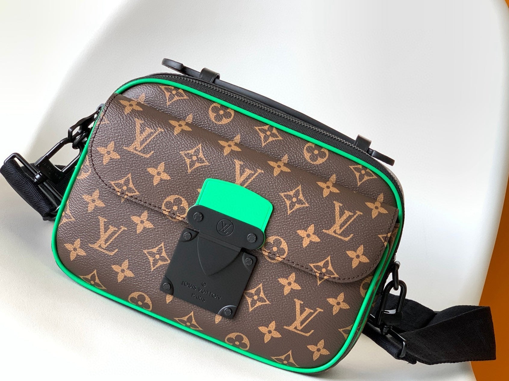 Designer handbag with monogram pattern on a white surface