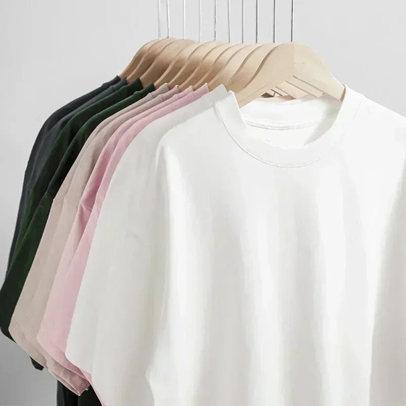 White sweatshirt on a hanger with other colored sweatshirts in the background.