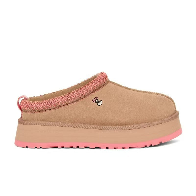 A single slip-on clog-style mule shoe in tan suede with a pink braided trim along the opening, a tan platform sole, and a bright pink outsole, shown on a plain white background.